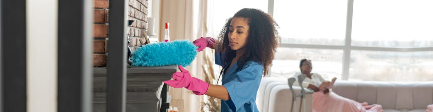 Staff member cleaning in a bright living room
