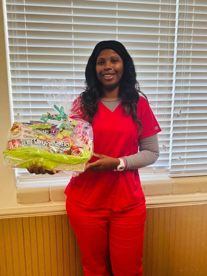 Staff member holding a gift basket in a facility interior