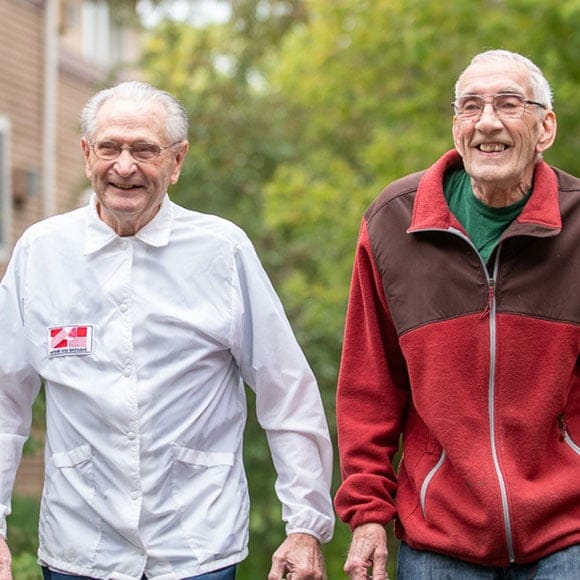 Two happy residents walking outside together
