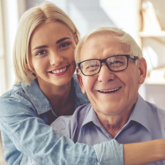 Resident and staff member smiling together