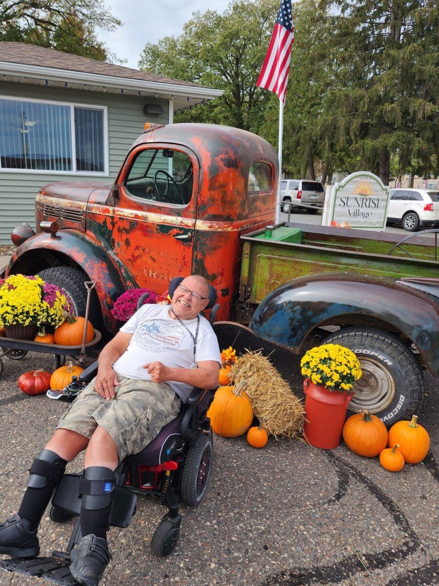 Resident posing next to a vintage truck during autumn decoration