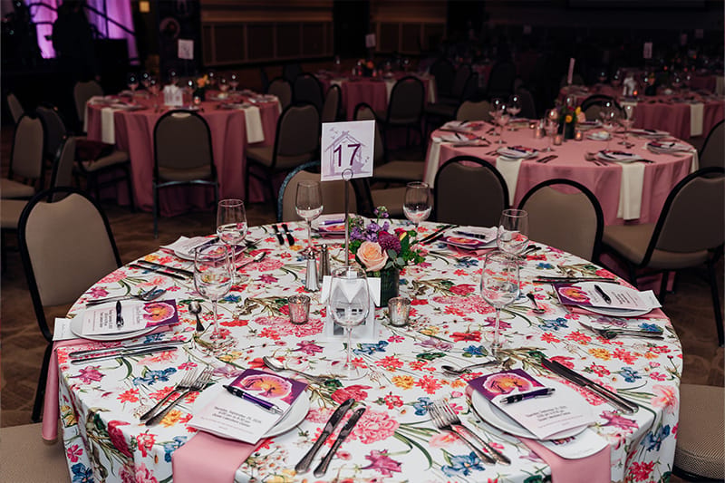 Elegant dining setup with floral tablecloth and decorations.