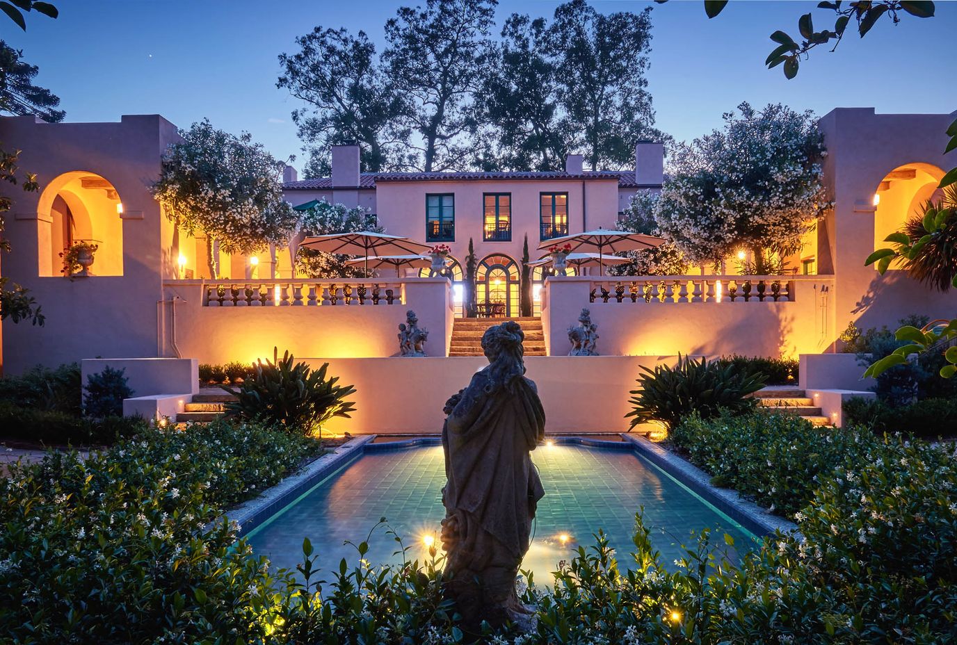 Exterior view of Casa Dorinda at dusk with fountain