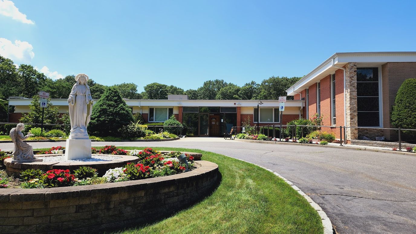 Exterior view of the facility with garden and statue.