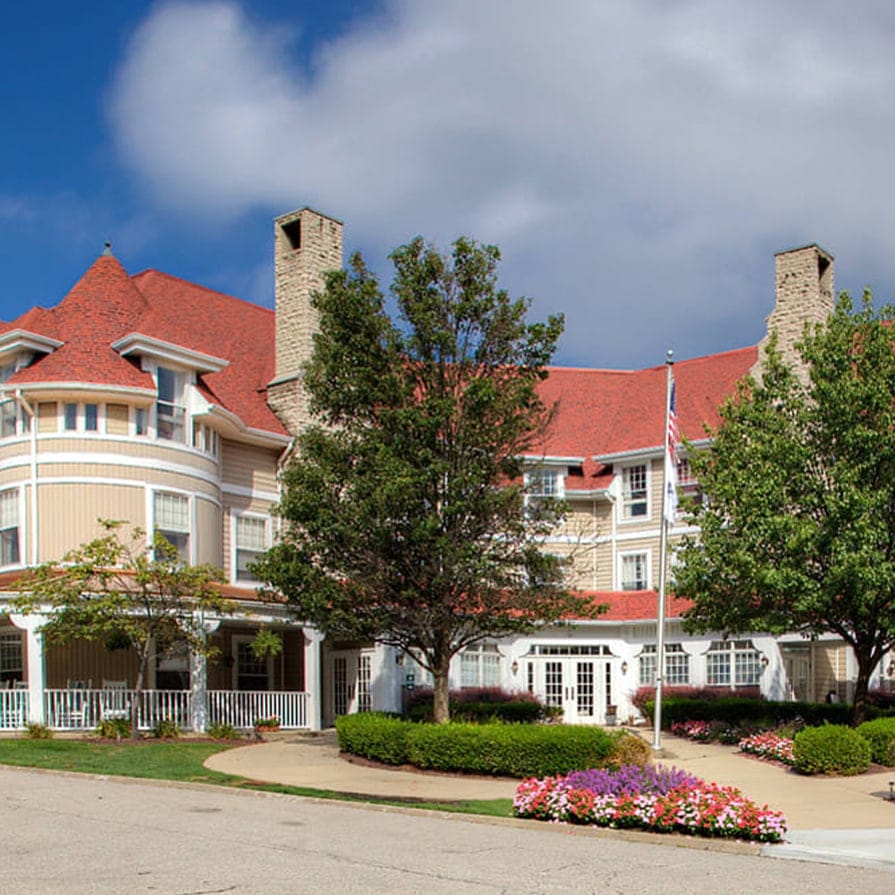 Exterior view of a senior living facility surrounded by flowers.