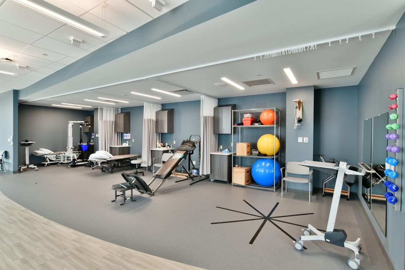 Therapy gym with exercise equipment and therapy balls.