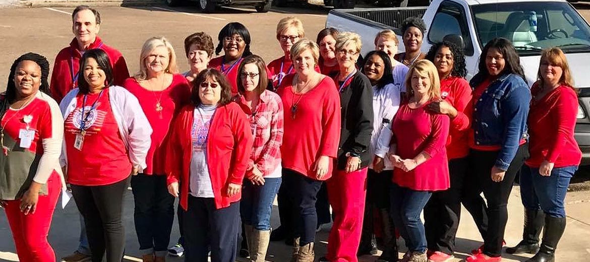 Staff members posing together outside the facility