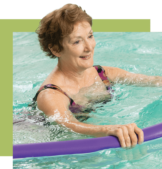 Resident swimming in an indoor pool with a flotation device