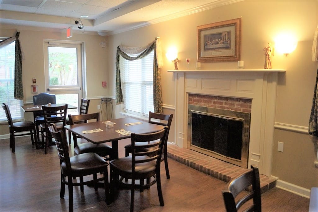 Dining area with tables and a fireplace.