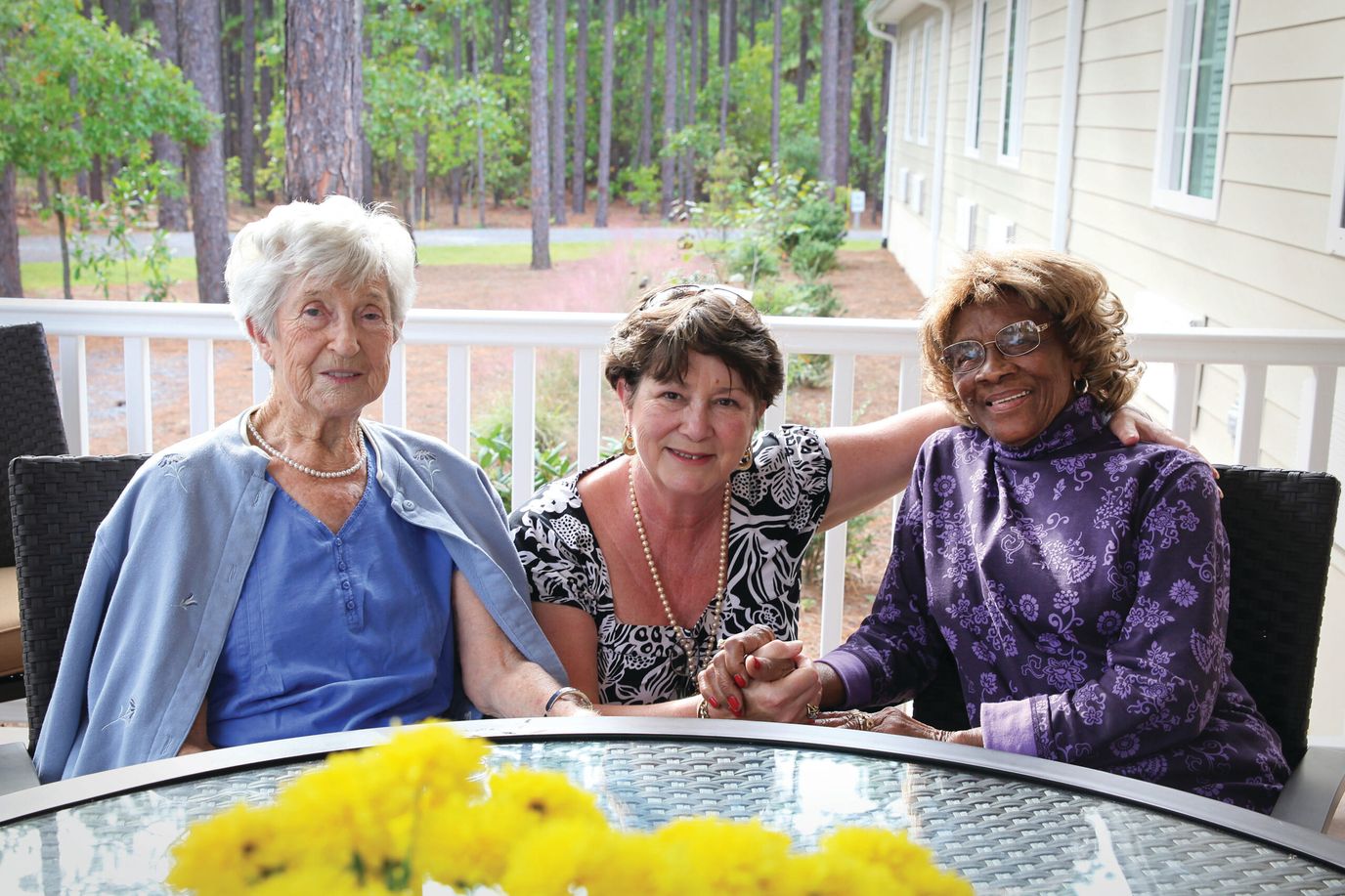 Three residents enjoying time together on a patio