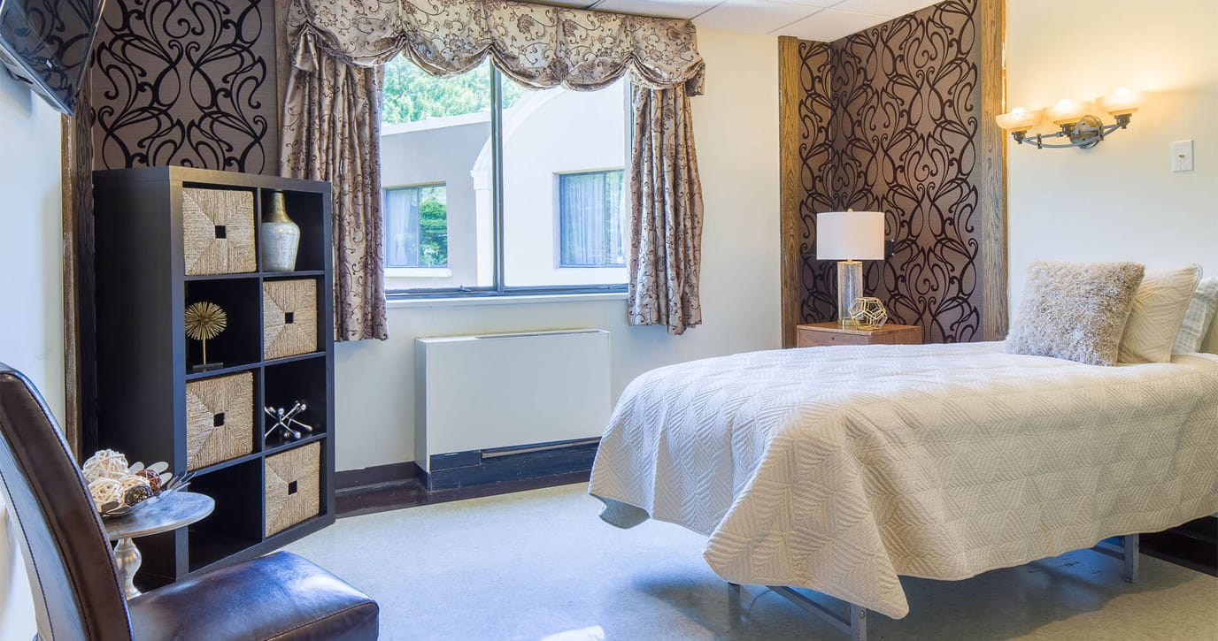 A private resident room with a cozy bed and décor