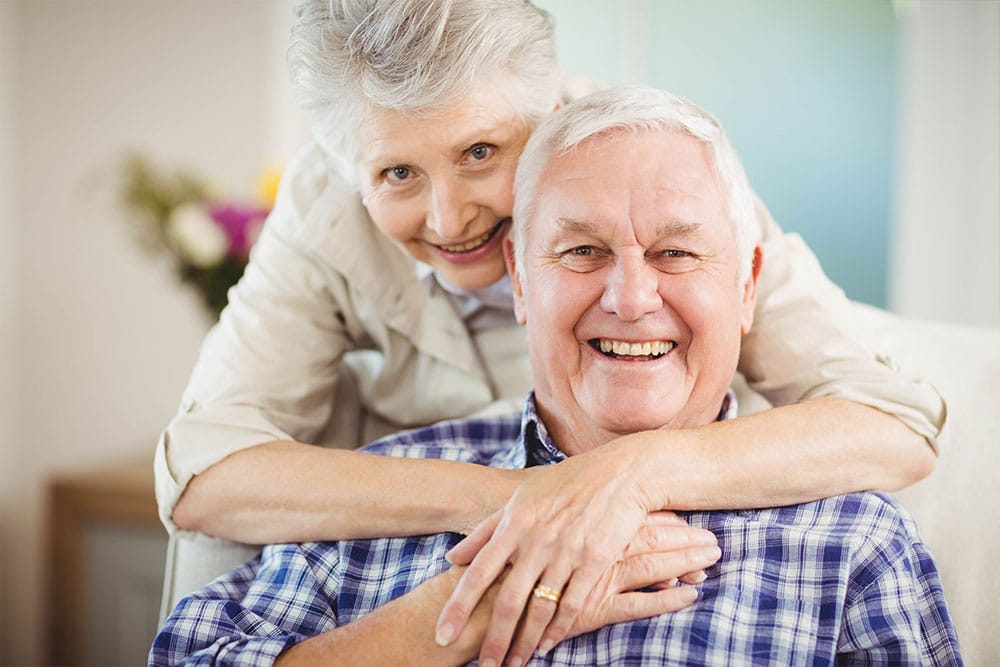 A smiling elderly couple in a comfortable setting