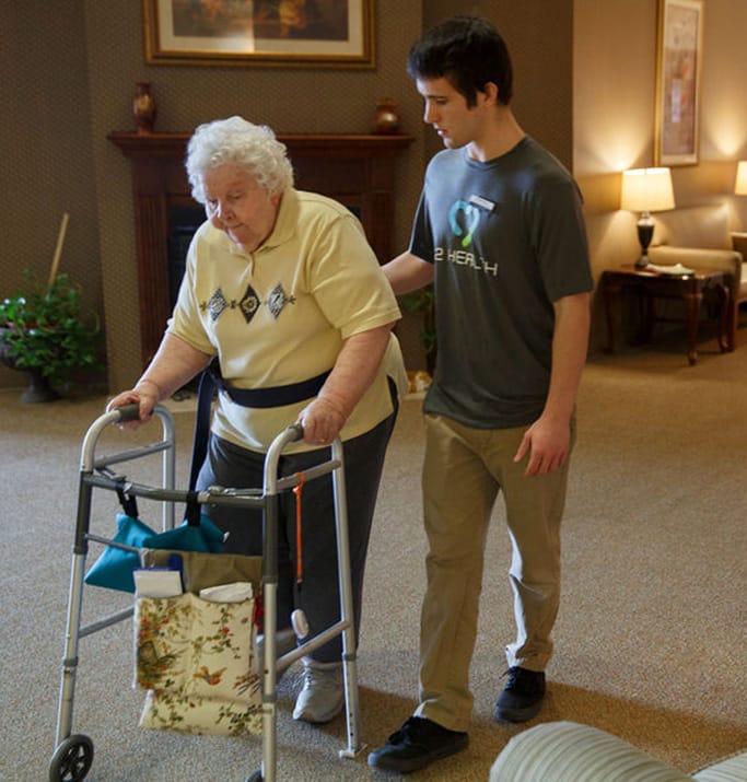 Staff assisting a resident using a walker indoors