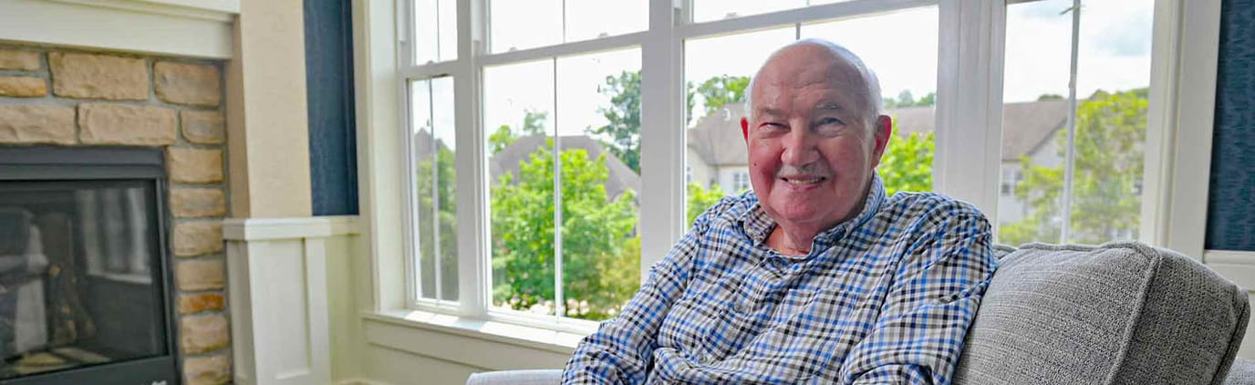 Resident smiling in a bright living area by the window