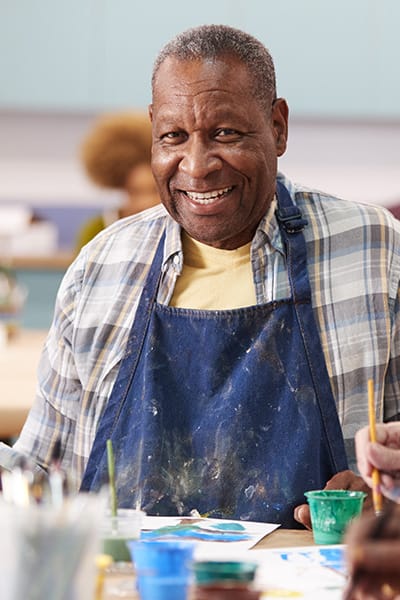 Resident enjoying a painting activity in the facility