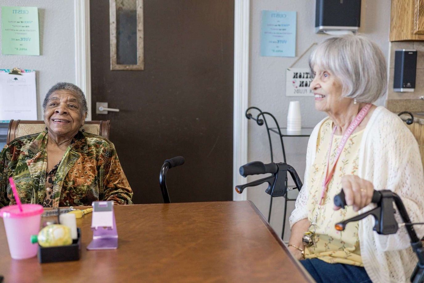 Two elderly women smiling in a cozy indoor setting
