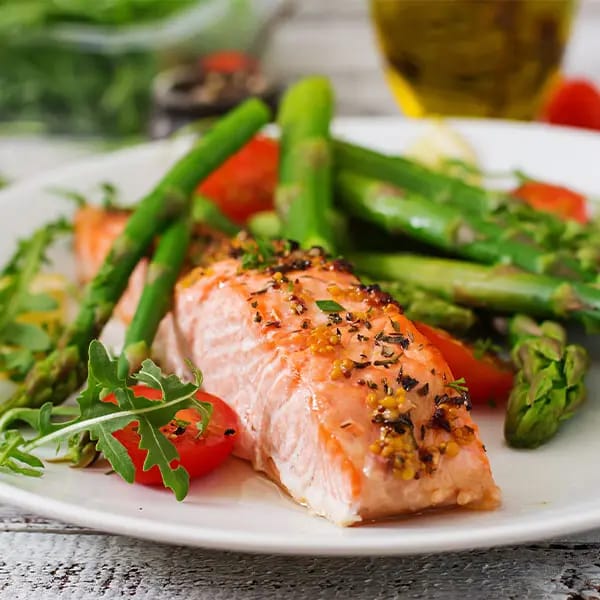 Plated meal of salmon and asparagus on a wooden table