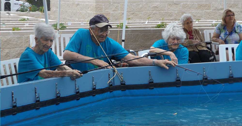 Residents fishing in a recreational pool during an activity