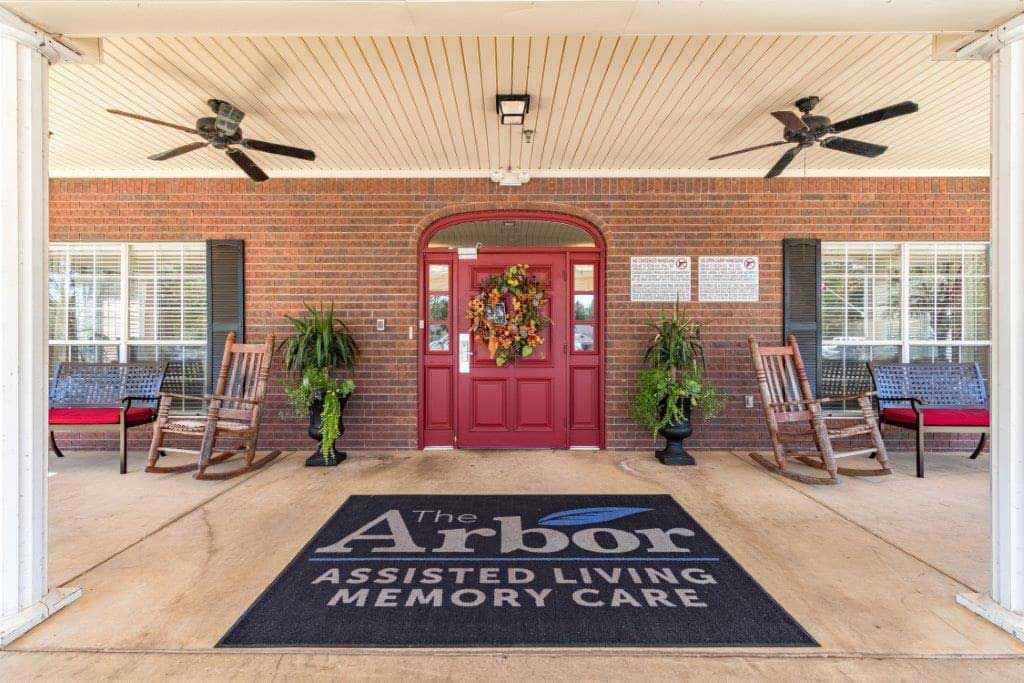 Exterior entrance of The Arbor Assisted Living with seating