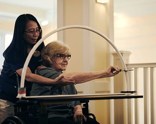 A staff member assisting a resident in a wellness activity