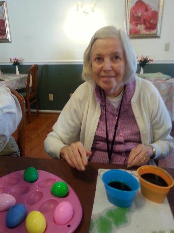 A resident participating in an activity with colored eggs
