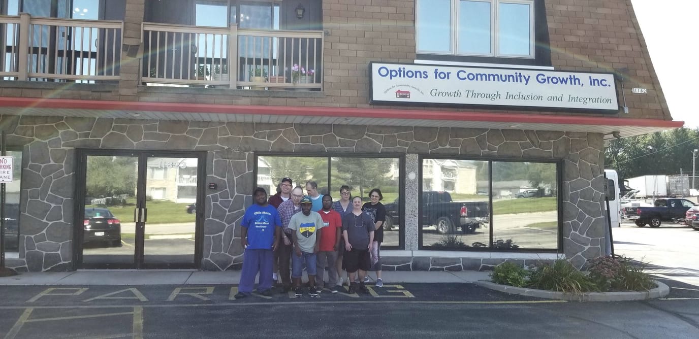 Group of people in front of a community growth facility