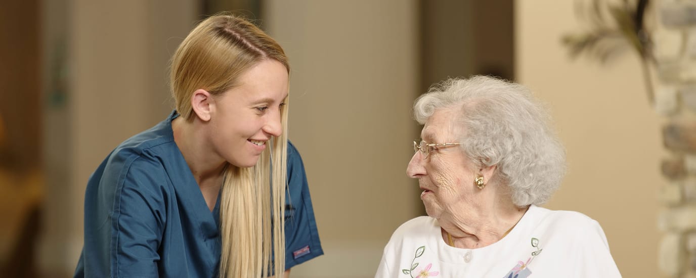 Caregiver interacting with elderly resident indoors