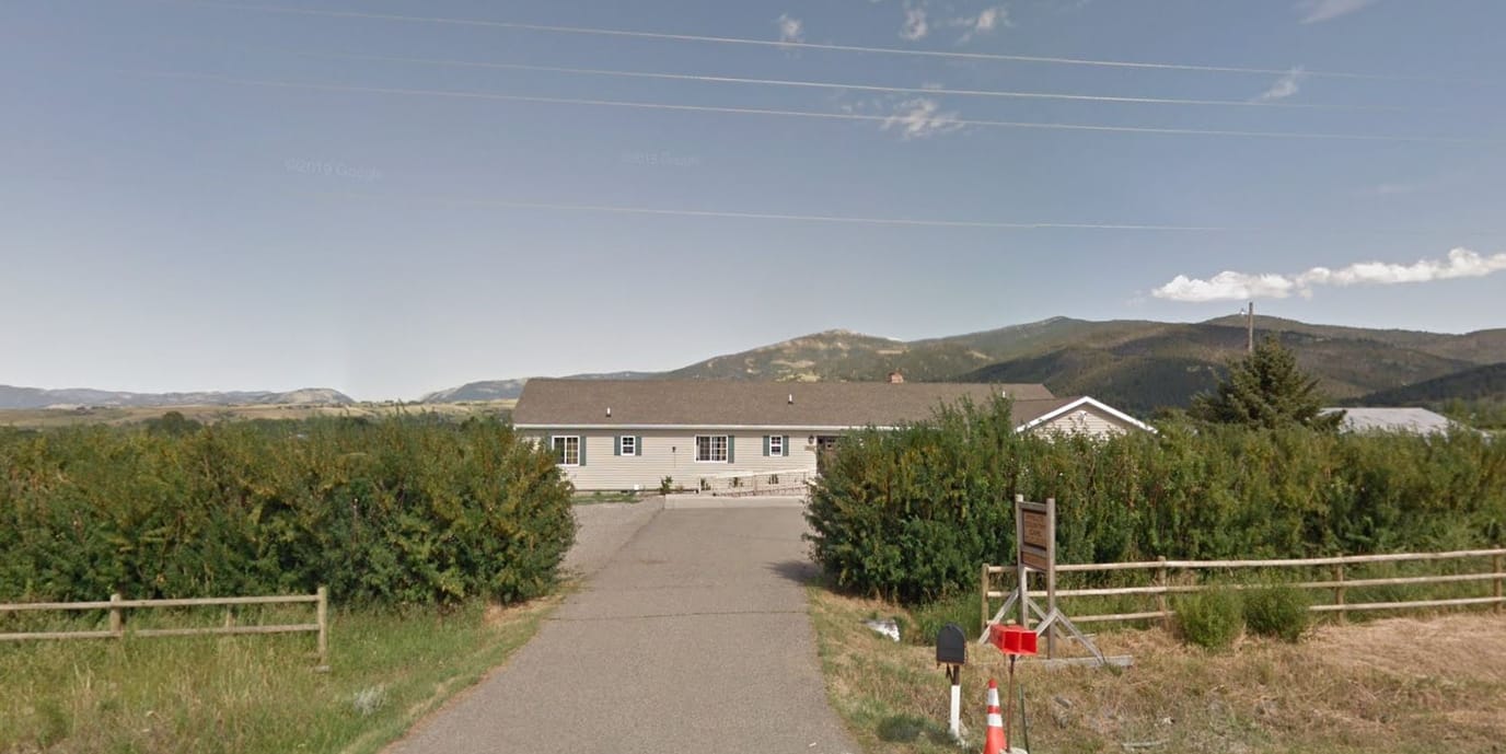 Exterior view of a senior care facility with mountains in the background