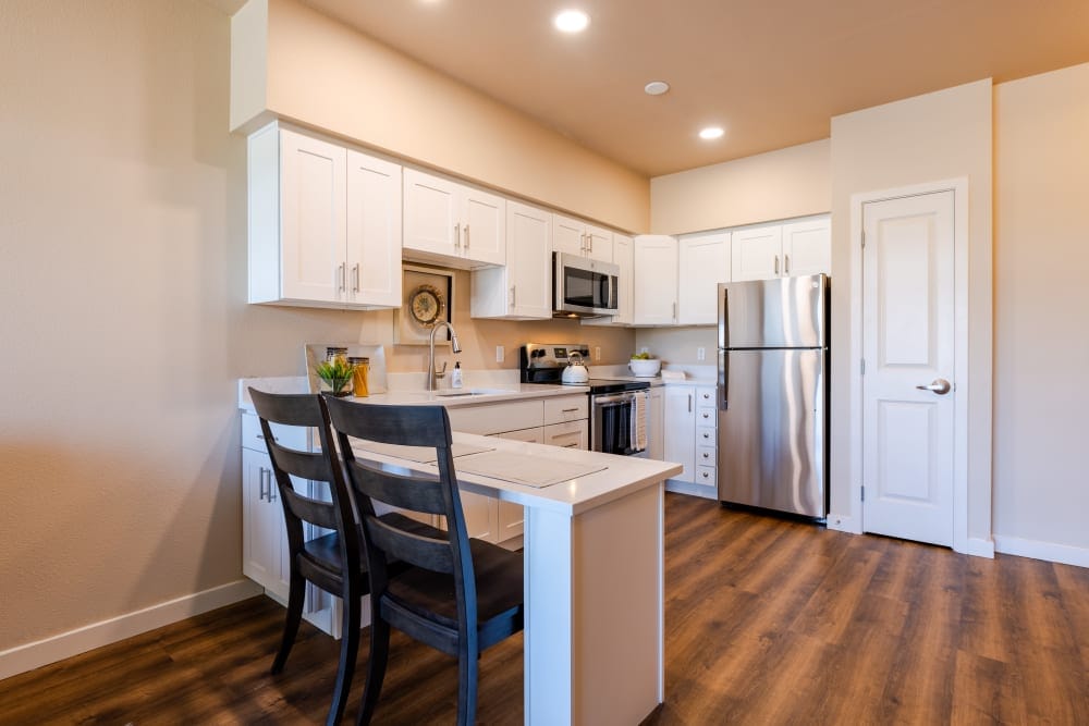 Modern kitchen with white cabinets and wooden flooring