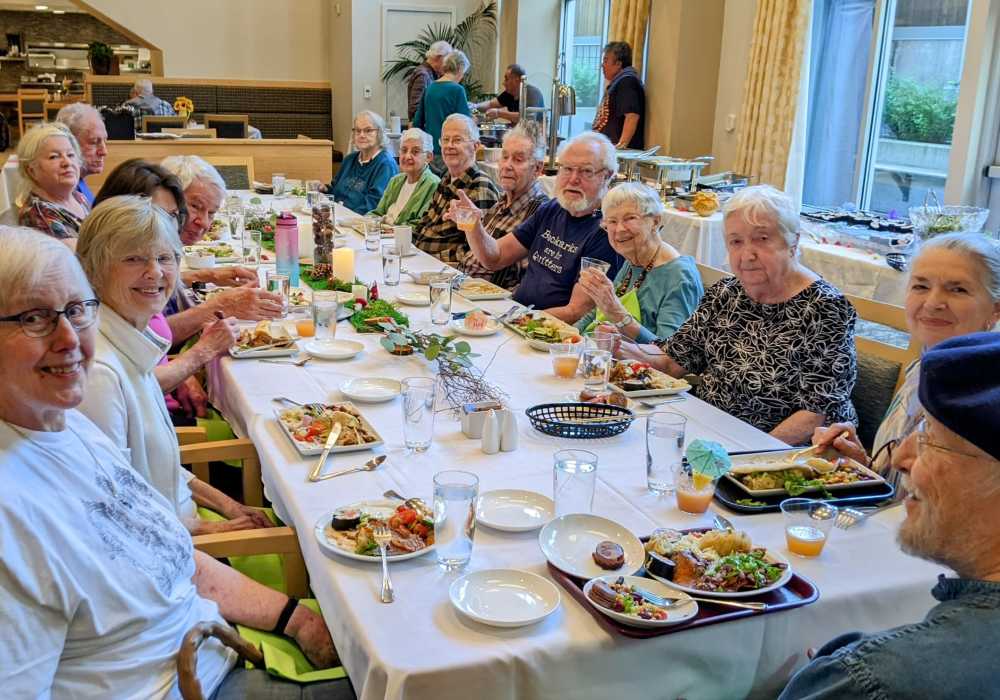Residents enjoying a meal together at a dining table.