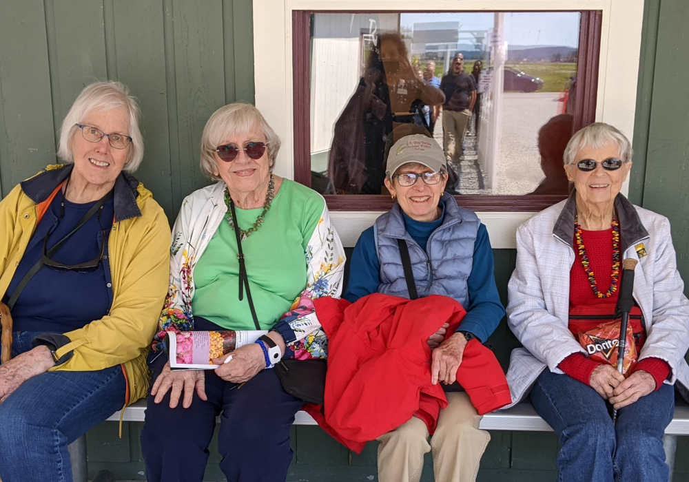Four residents enjoying a sunny outdoor space.
