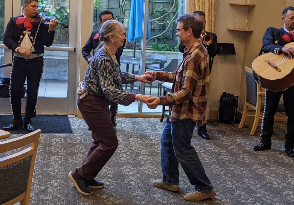 Residents dancing with a mariachi band performance.