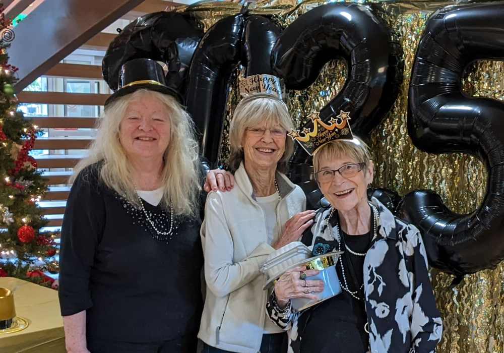 Three residents celebrating together with festive decorations.