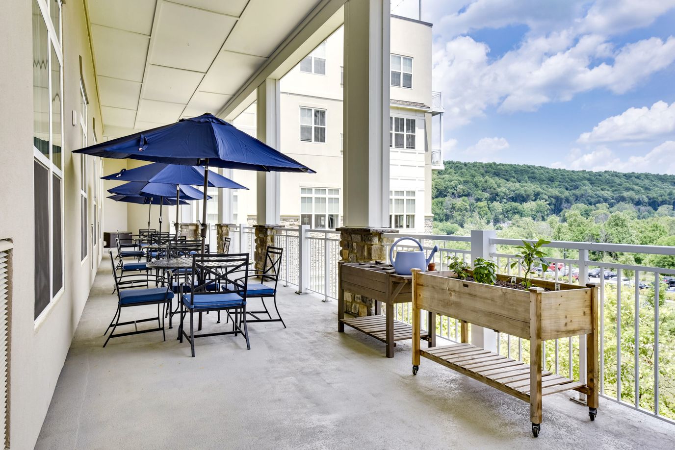Outdoor seating area with blue umbrellas and greenery
