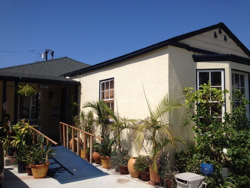 Exterior view of a senior living facility entrance with plants