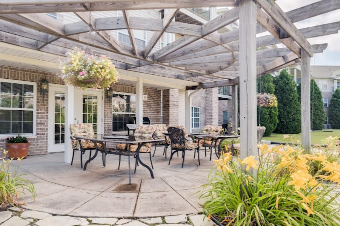 Outdoor seating area with flowers and seating under a pergola