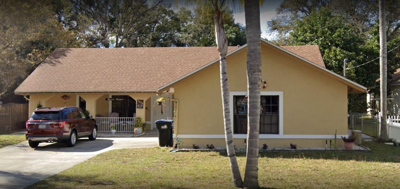 Exterior view of Marie's Manor Assisted Living with a vehicle