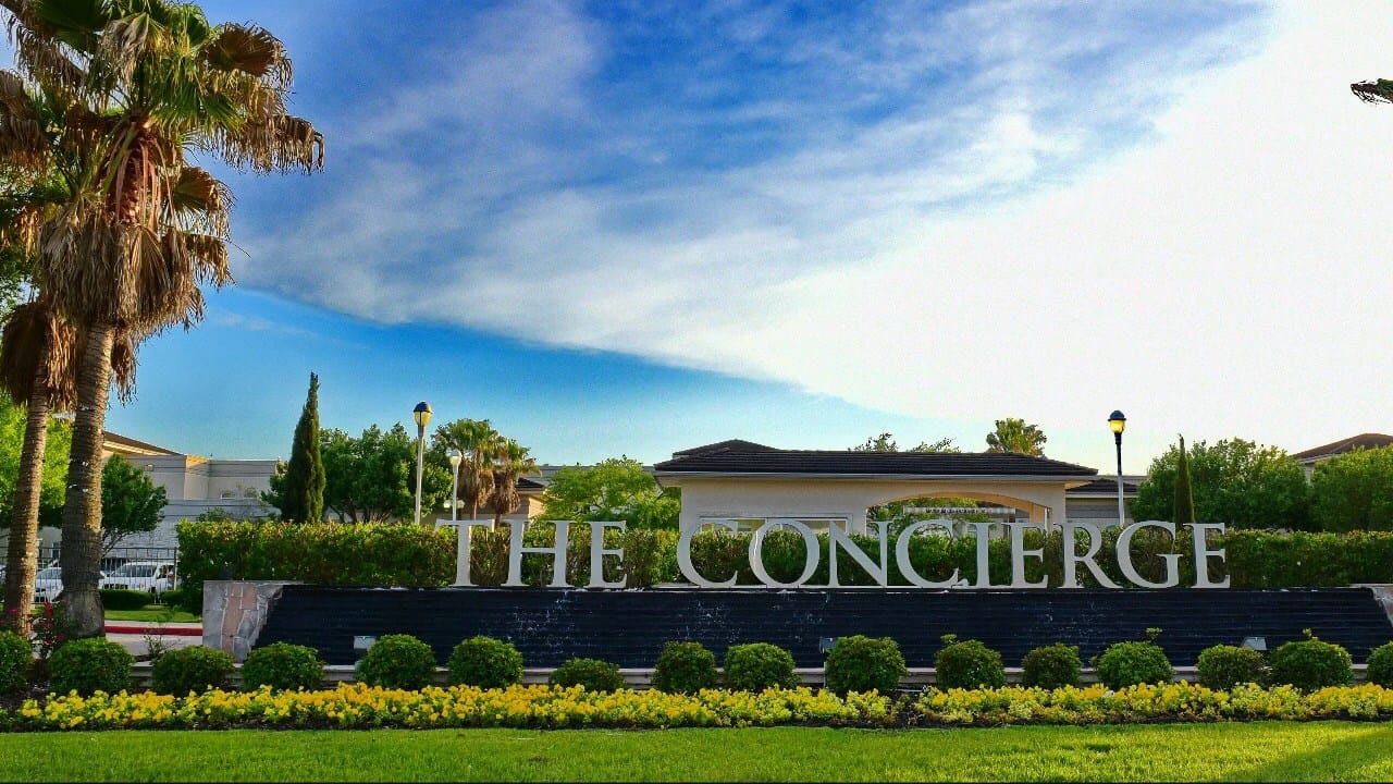 Signage for The Concierge facility with outdoor landscaping