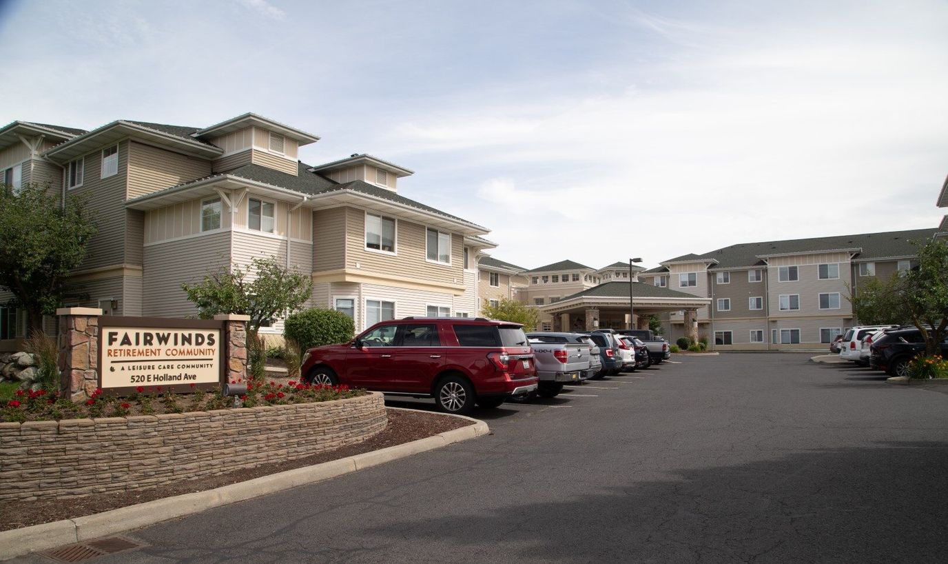 Exterior view of Fairwinds Retirement Community with parking