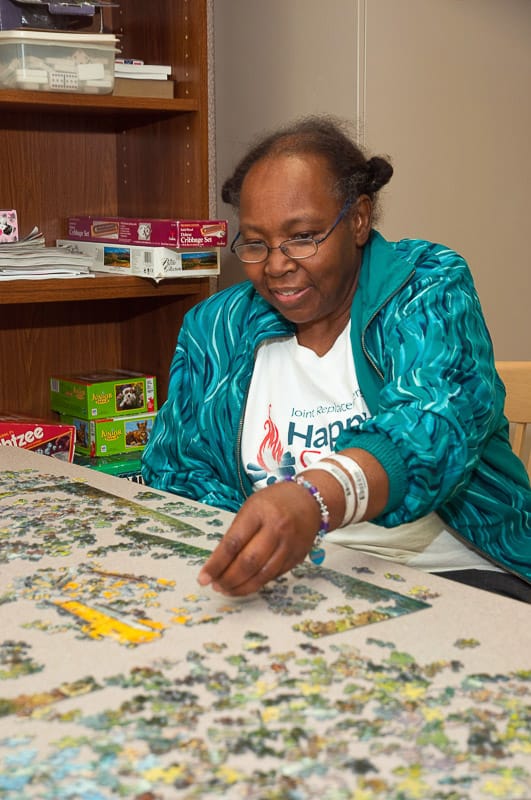 Resident working on a puzzle in an activity room