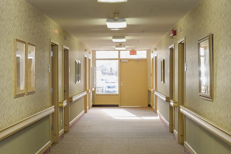 Well-lit hallway in a nursing home facility