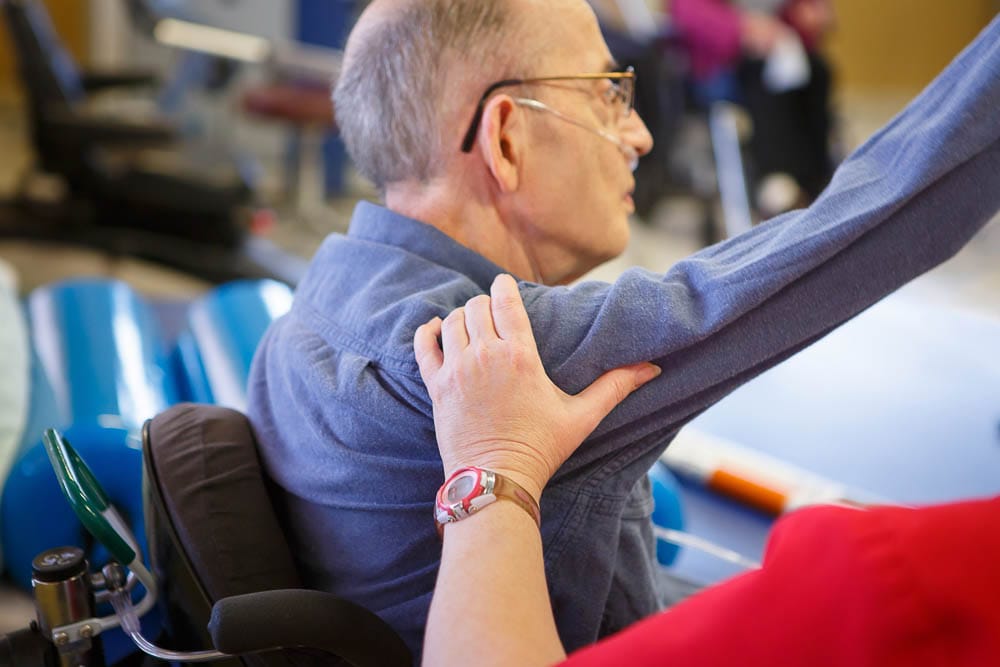 Staff assisting a resident during therapy.