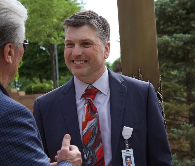 A staff member interacting with a visitor outdoors
