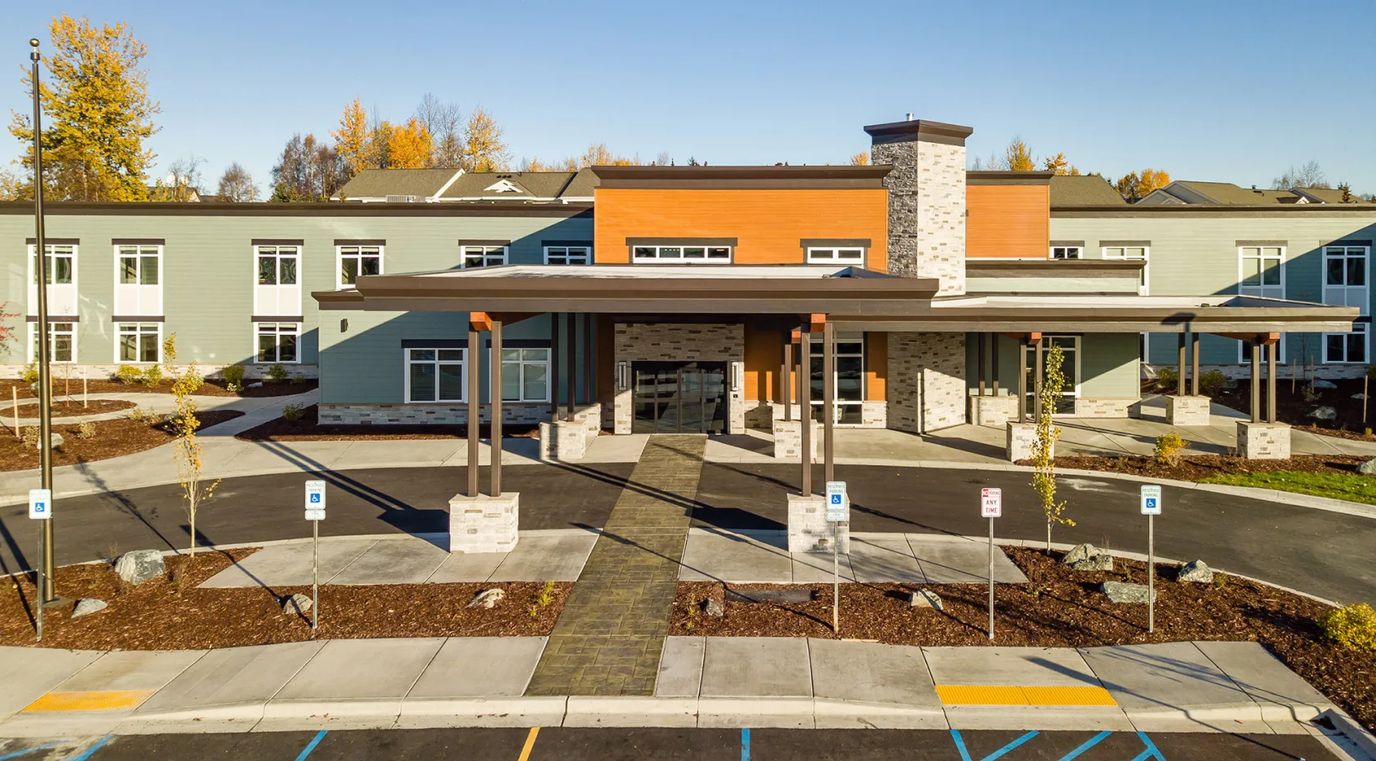 Exterior view of Aspen Creek Riverside with entrance and landscaping