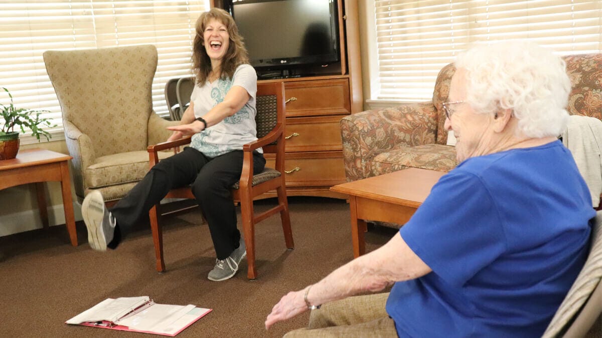 A staff member engaging in exercise with a resident