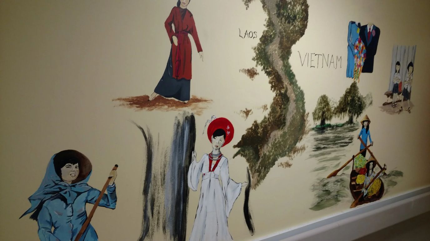 Mural depicting cultural scenes on an interior wall.