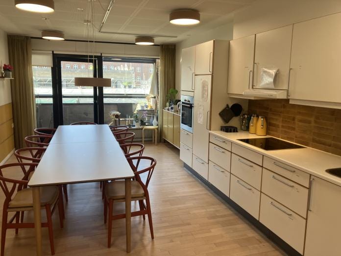 Bright dining area with a large table and kitchen.