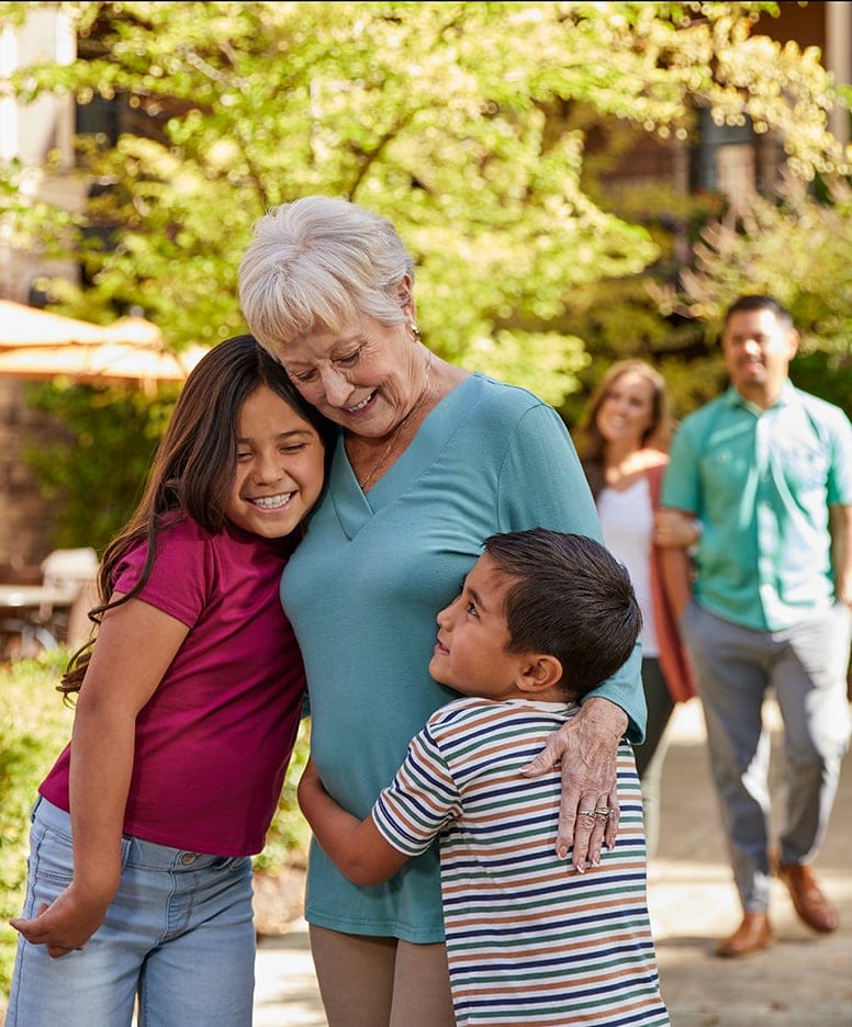 Smiling senior woman with children in a garden