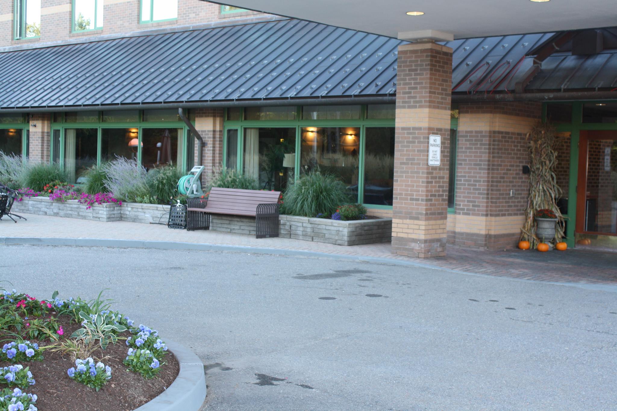 Entrance of Eisenberg Assisted Living Residence with flowers and seating
