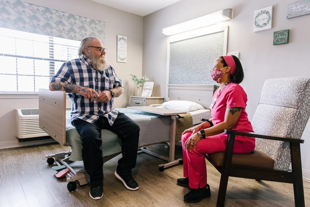 A resident chatting with a staff member in a private room